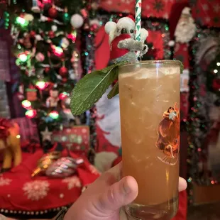 a hand holding a glass of iced tea
