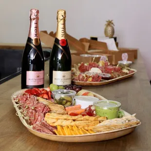 two bottles of champagne and a platter of appetizers