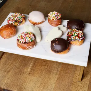 a variety of doughnuts on a white plate