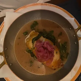 a bowl of soup with meat and greens