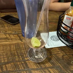 a glass of water with a lime wedge in it