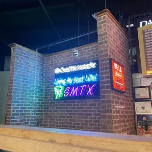 a brick wall with a neon sign