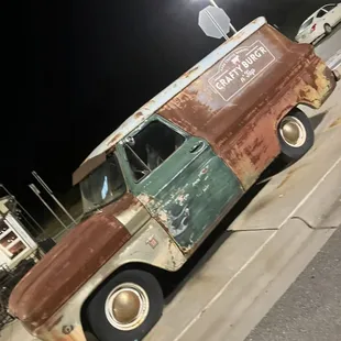 an old truck parked on the side of the road