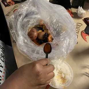 a person holding a spoon over a bowl of food