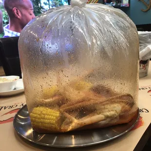 Seafood boil with shrimp and crab, garlic butter sauce. It comes with potatoes and corn.