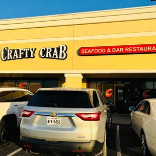 cars parked in front of a crafty crab restaurant