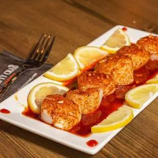 a plate of fish with lemon slices