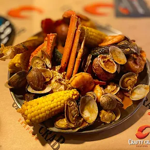 a plate of clams, corn, and sausage