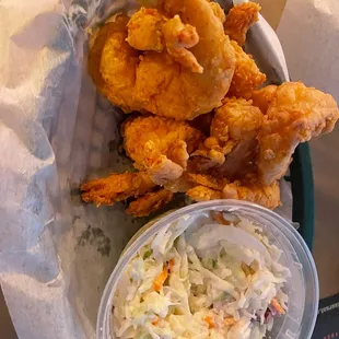 a basket of fried shrimp and coleslaw