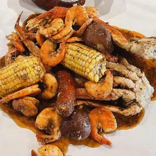 a plate of crab - wauwatosa with corn and potatoes