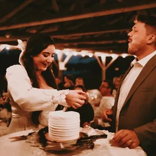 a bride and groom cutting their wedding cake