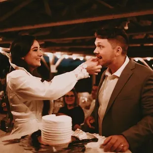 a man feeding a woman a piece of cake