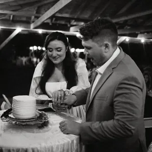 a bride and groom cutting their wedding cake