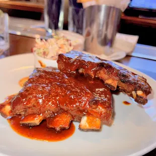 a plate of ribs covered in bbq sauce