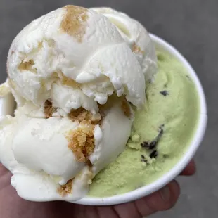a hand holding a bowl of ice cream