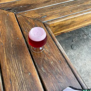 a glass of beer on a wooden bench