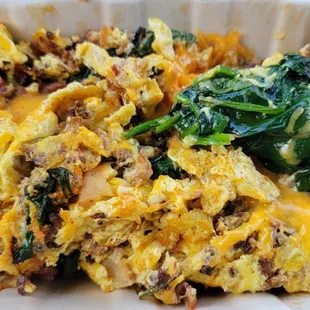 Breakfast bowl with eggs, bacon, chorizo, spinach, and cheddar cheese