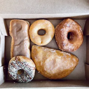 top, left to right: maple long john, glazed raised, crosonut bottom, left to right: samoa, cheese pocket