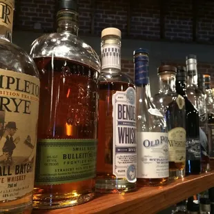 a row of liquor bottles on a bar shelf