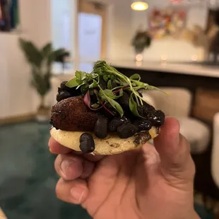 a person holding a sandwich in their hand