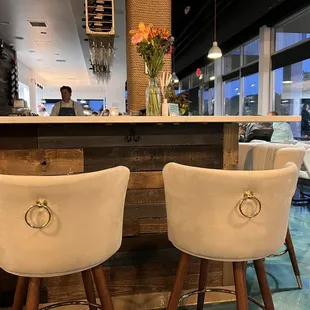 a view of a bar with white chairs