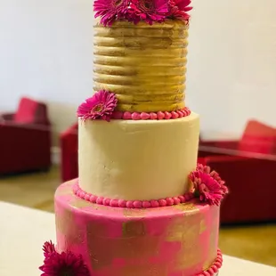 a three tiered cake with pink flowers