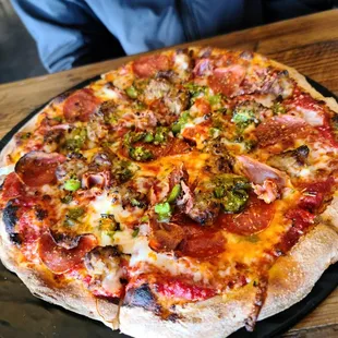 a pizza on a black plate on a wooden table