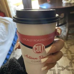 a person holding a cup of coffee