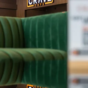 a green couch and a sign for crave