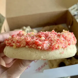 a hand holding a half eaten doughnut