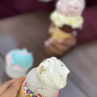 a person holding an ice cream cone with sprinkles