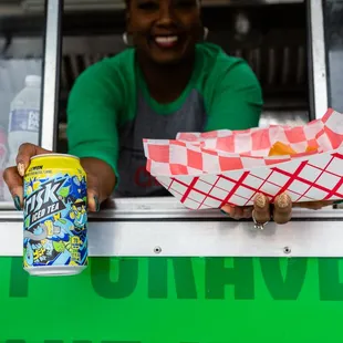 a woman holding a can of soda