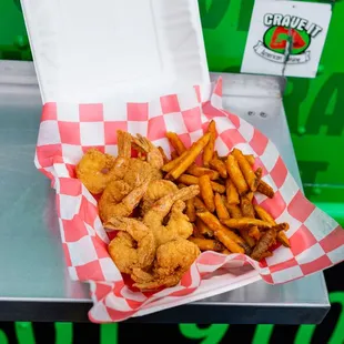 a basket of fried shrimp and fries