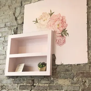 a brick wall with a shelf with a plant on it