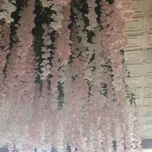 pink and white flowers hanging from the ceiling