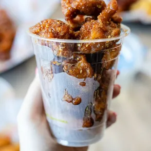 a hand holding a cup of food