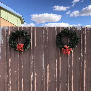 wo wreaths on a fence