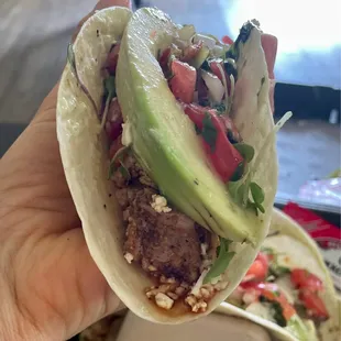  a hand holding a taco