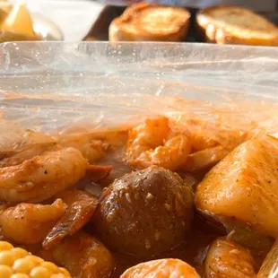 a plastic container filled with shrimp and corn