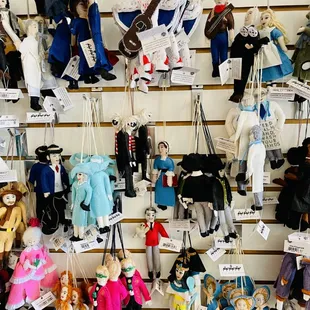 a variety of dolls hanging on a wall