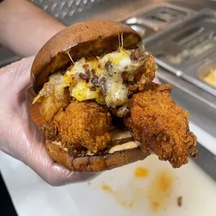 a hand holding a fried chicken sandwich