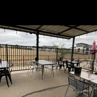 a patio with tables and chairs