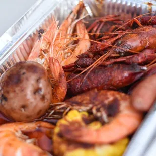 shrimp, sausage, and potatoes in a foil container