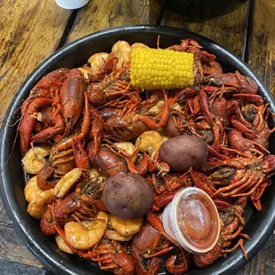 a bowl of crawfish, potatoes and corn