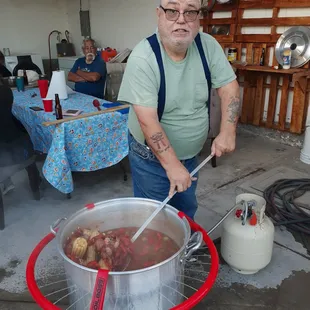 a man stirring up a pot of crawfish