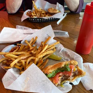 a woman eating a sandwich and french fries