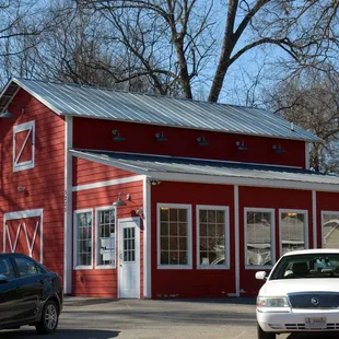 a car parked in front of a red building