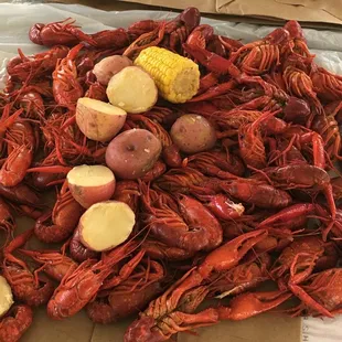Crawfish with boiled potatoes, corn, and a boudin link.