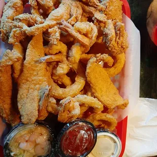 Fried catfish strips, shrimp, and chicken strips, onion rings, hush puppies, shrimp slaw