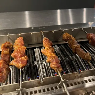 bacon and sausages cooking on a grill